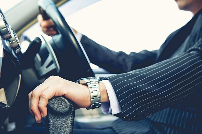 Man In Suit With Hands On The Wheel